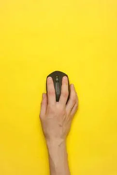Hand using computer mouse on yellow background Stock Photos