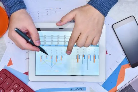 Hand using digital tablet and checking stock market data. Foto stock