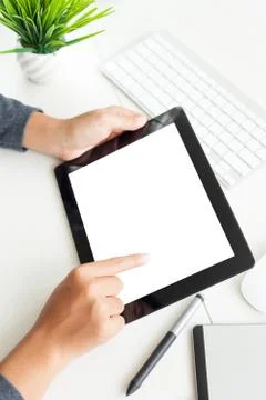 Hand using digital tablet on desk vertical view Stock Photos
