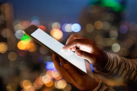 Hand using digital tablet on night beauty light bokeh in city Stock Photos
