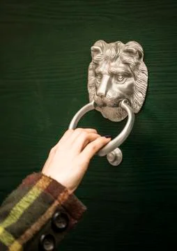 Hand using a door knocker Stock Photos