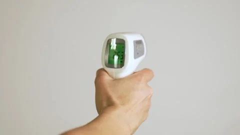 Hand using infrared thermometer, white background Stock Footage 261003785