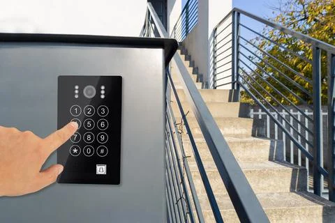 Hand using keypad on modern security system by stairs Stock-Fotos
