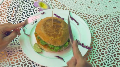 Hand using knife and fork cutting burger Stock Footage 95780304