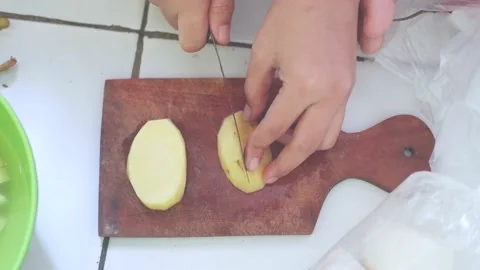 Hand using knife to cut the potatoes. top view Stock Footage 157592164