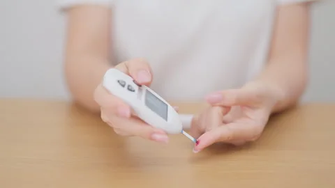 Hand using lancet pen on finger with Blood drop glucose testing or Diabetes.. Stock Footage 329818575