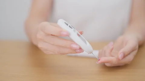 Hand using lancet pen on finger with Blood drop glucose testing or Diabetes.. Stock Footage 337926080