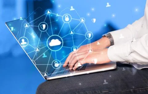 Hand using laptop with centralized linked cloud system concept Stock Photos