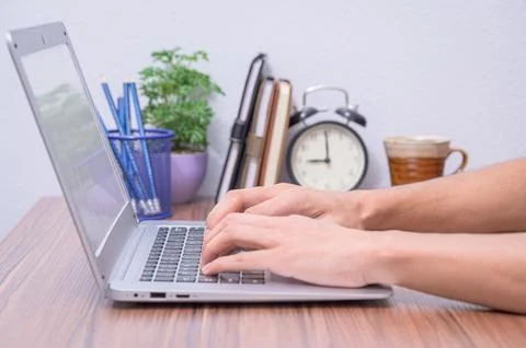Hand using a laptop computer At the desk in the room Stock Photos