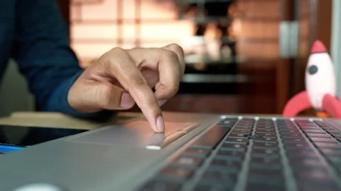 Hand Using Laptop Touchpad with Toy Rocket Nearby Stock Footage 320724281