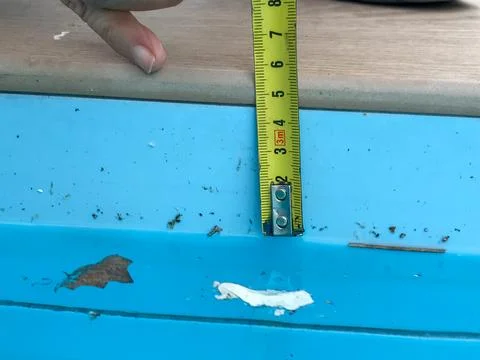 Hand using measuring tape checking pool edge depth Fotos Stock