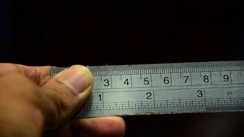 Hand using metal ruler to measure on black background Stock Footage 84932379