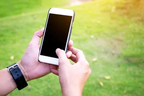 Hand Using Mobile phone with blank screen in the park Vintage Tone Stock Photos
