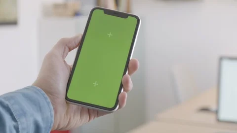 Hand using mobile phone with greenscreen in office Stock Footage 125693265