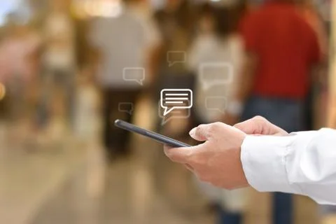 Hand using mobile phone typing, with chat icons. Social media and technology  Stock Photos
