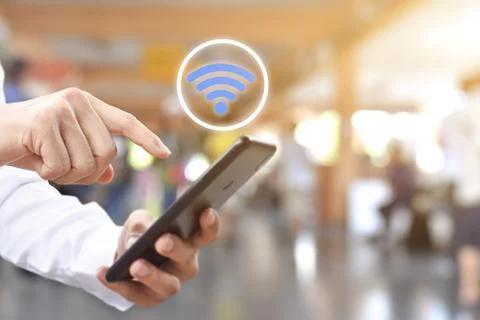 Hand using mobile smartphone with wifi icon. Stock Photos