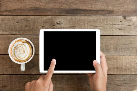 Hand using mock up tablet on wood desk with clipping path display easy add el Stock Photos