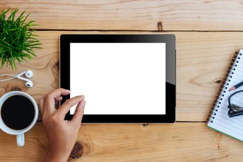 Hand using mockup tablet on wood desk white display with clippin Stock Photos