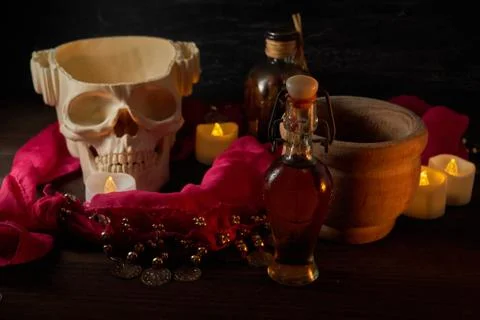Hand using mortar Scary still life with potions, skull, mortar, vintage bottl Foto stock