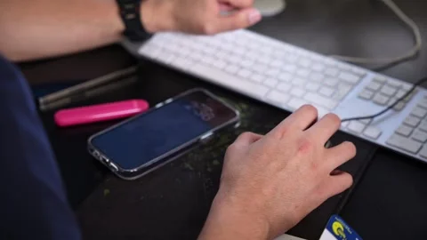 Hand Using Mouse at Computer Desk with Smartphone and Keyboard Stock Footage 333871152