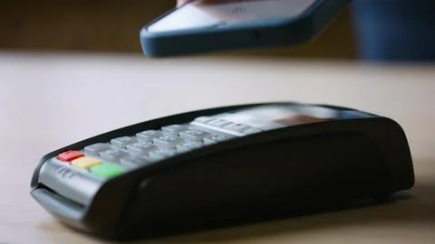 Hand using nfc technology on cellphone for purchase closeup. Terminal payment Stock Photos