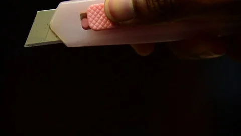 Hand using penknife on black background Stock Footage 84918016