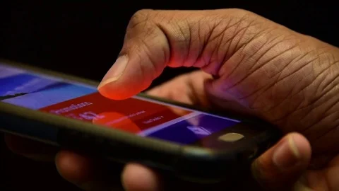 Hand using phone and scrolling up and down on black background Stock Footage 84940873