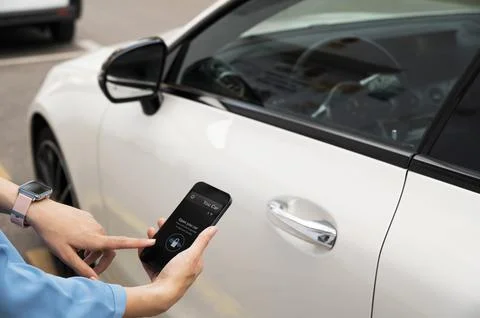 Hand using phone to unlock car close up Stock Photos