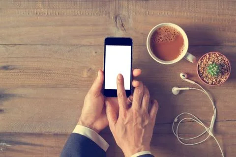 Hand using phone with white screen on wooden background, Top view 스톡 사진