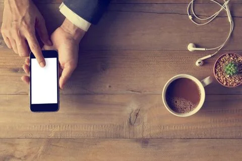 Hand using phone white screen on wooden background, Top view Stock-Fotos