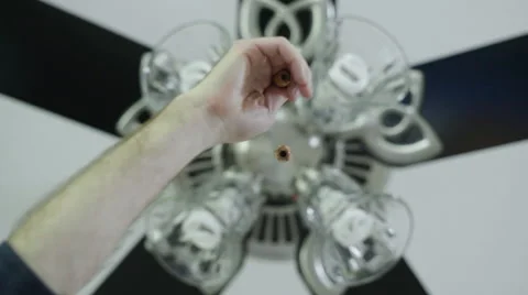 Hand using the pull cord to turn a Ceiling fan light on Stock Footage 63213655
