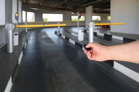 A hand using a remote control opens an automatic barrier in a parking lot Stockfoto's