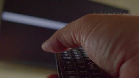 A hand using a remote control to turn off a modern TV Stock Footage 335648433