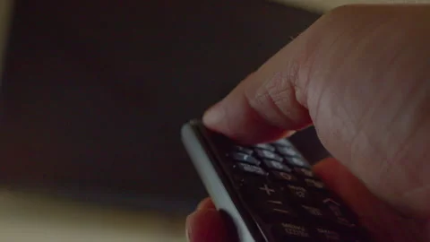 A hand using a remote control to turn on a modern TV Stock Footage 335649093