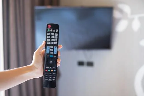Hand using remote controller for adjust Smart TV inside the modern room at ho Foto stock