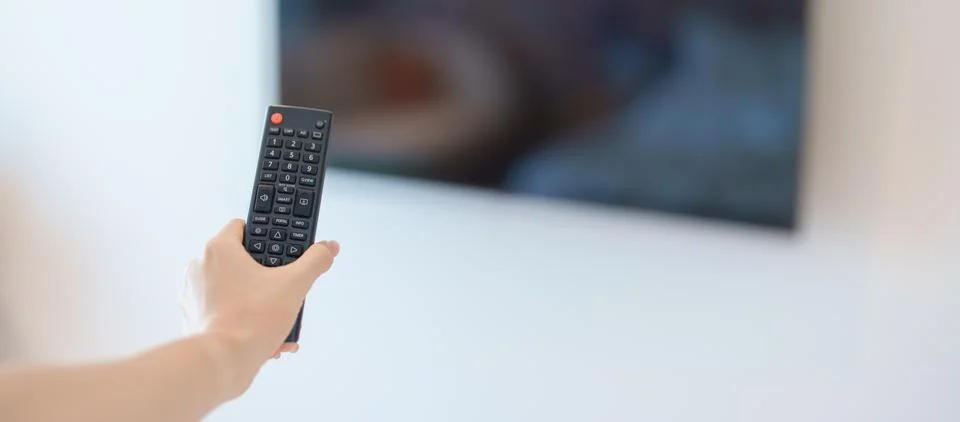 Hand using remote controller press button for adjust Smart TV in modern roo.. Stock Photos