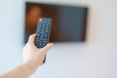 Hand using remote controller press button for adjust Smart TV in modern roo.. Stock Photos