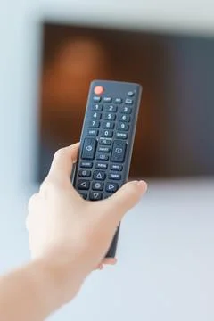 Hand using remote controller press button for adjust Smart TV in modern roo.. Stock Photos