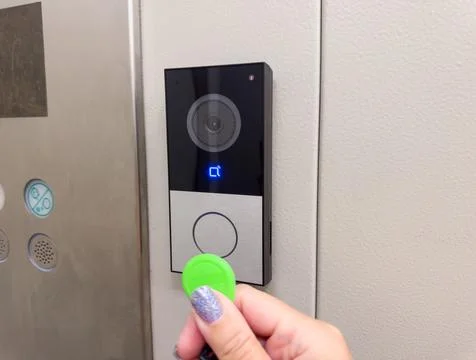 Hand using RFID key fob on smart video intercom access control system at mo.. Stock Photos