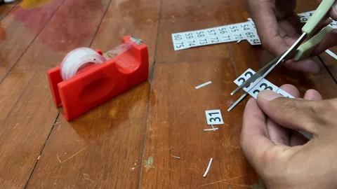 Hand using scissor to cut paper number on wooden floor. Home DIY concept Stock Footage 256703607