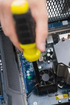 Hand using screw drive to fix processor fan Foto stock