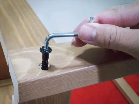 Hand Using Screw Driver to Assemble Wooden Chair Foto stock