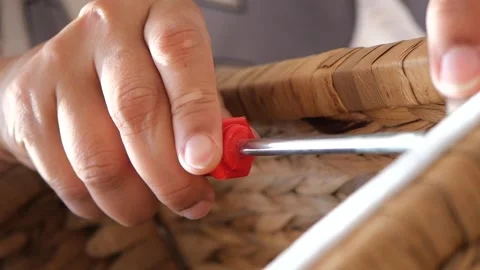 Hand using screwdriver to assemble wicker storage basket at home Vídeo Stock 308068802