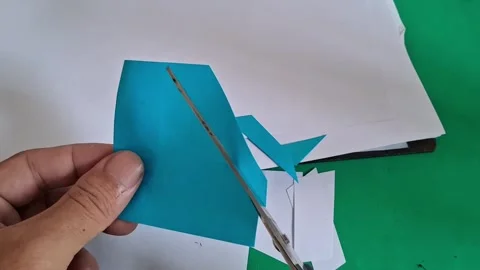 Hand using sharp metal scissors cutting blue paper craft video Stock Footage 339374520