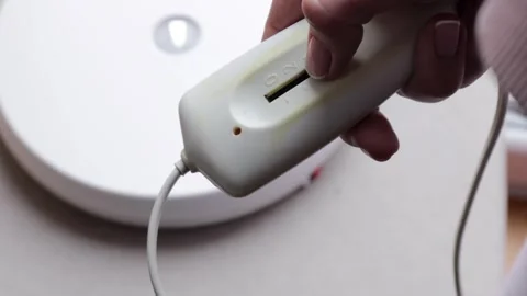 Hand using a slider switch on a wired electric heating pad controller to ch.. Stock Footage 320736753
