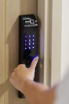 Hand using smart digital door lock while open or close the door at home or .. Stock Photos