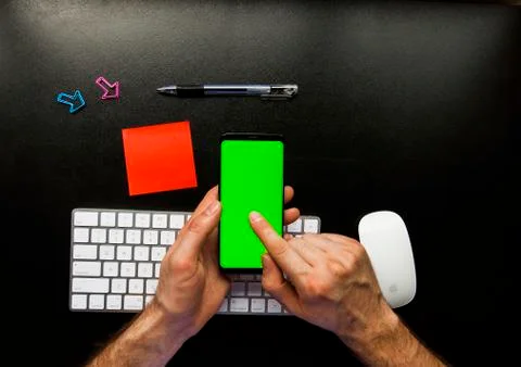 Hand using the smart phone on desk with keyboard and copy space Stock Photos
