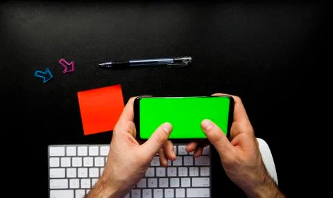 Hand using the smart phone on desk with keyboard and copy space Stock Photos