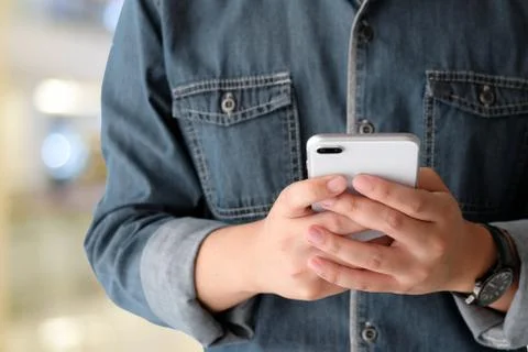 Hand using smart phone over blur bokeh light background, business and technol Stock Photos