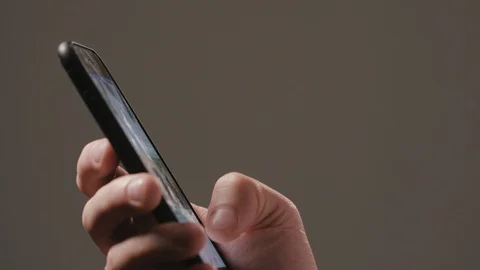 A Hand Using a Smartphone Against a Dark Background Stock Footage 88454016